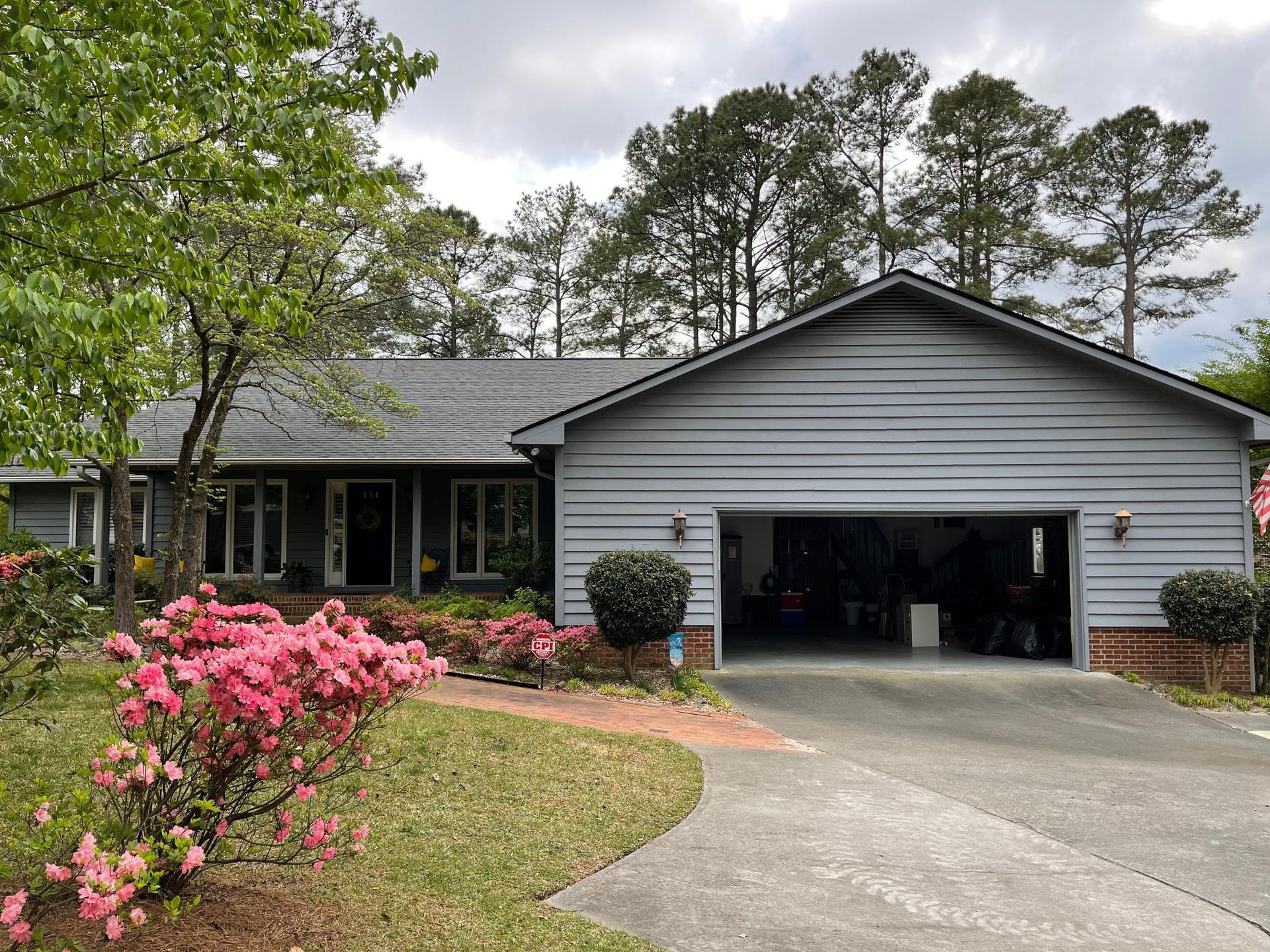 A house with a garage and flowers in front of it