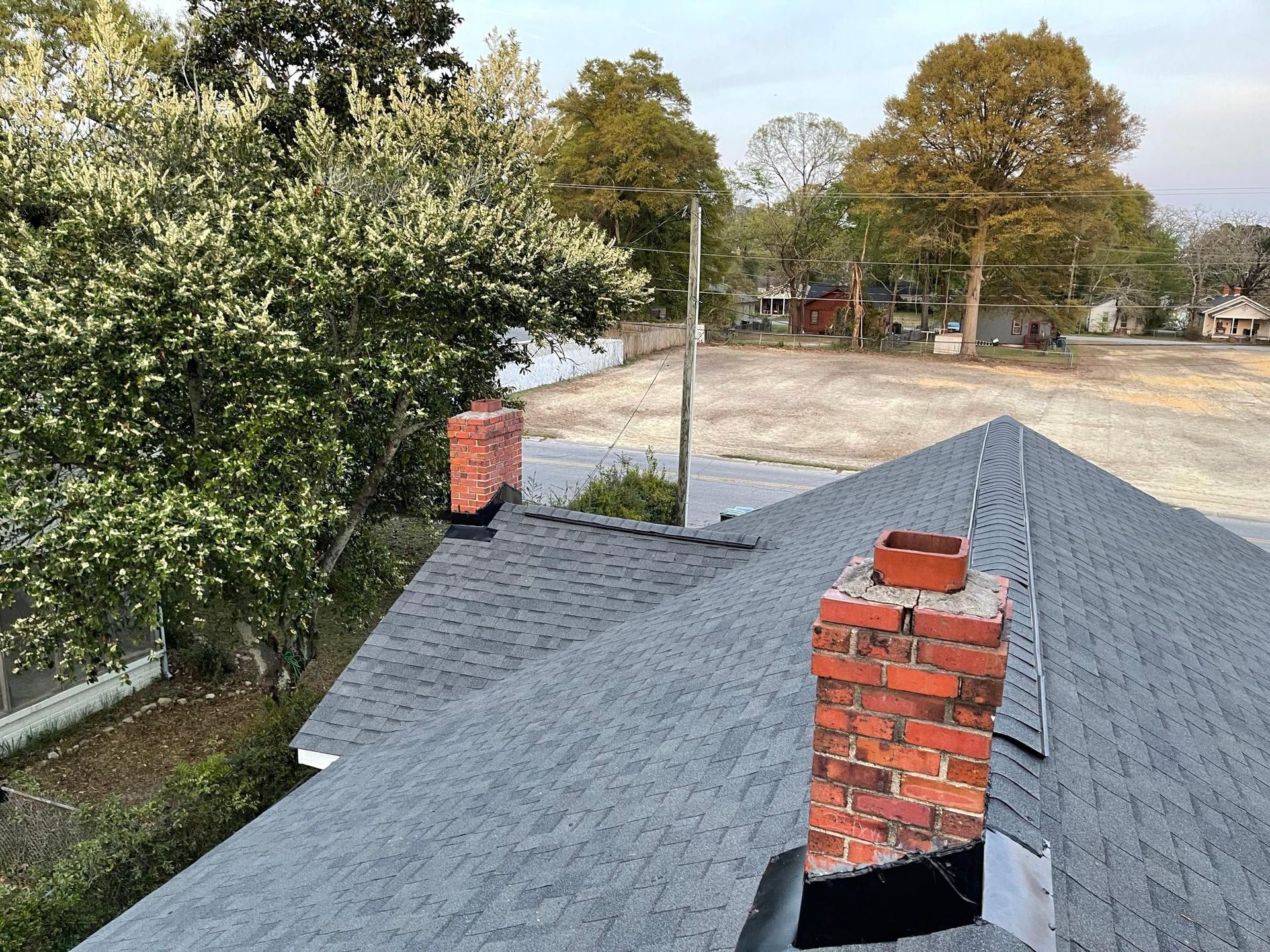 There are two chimneys on the roof of a house.