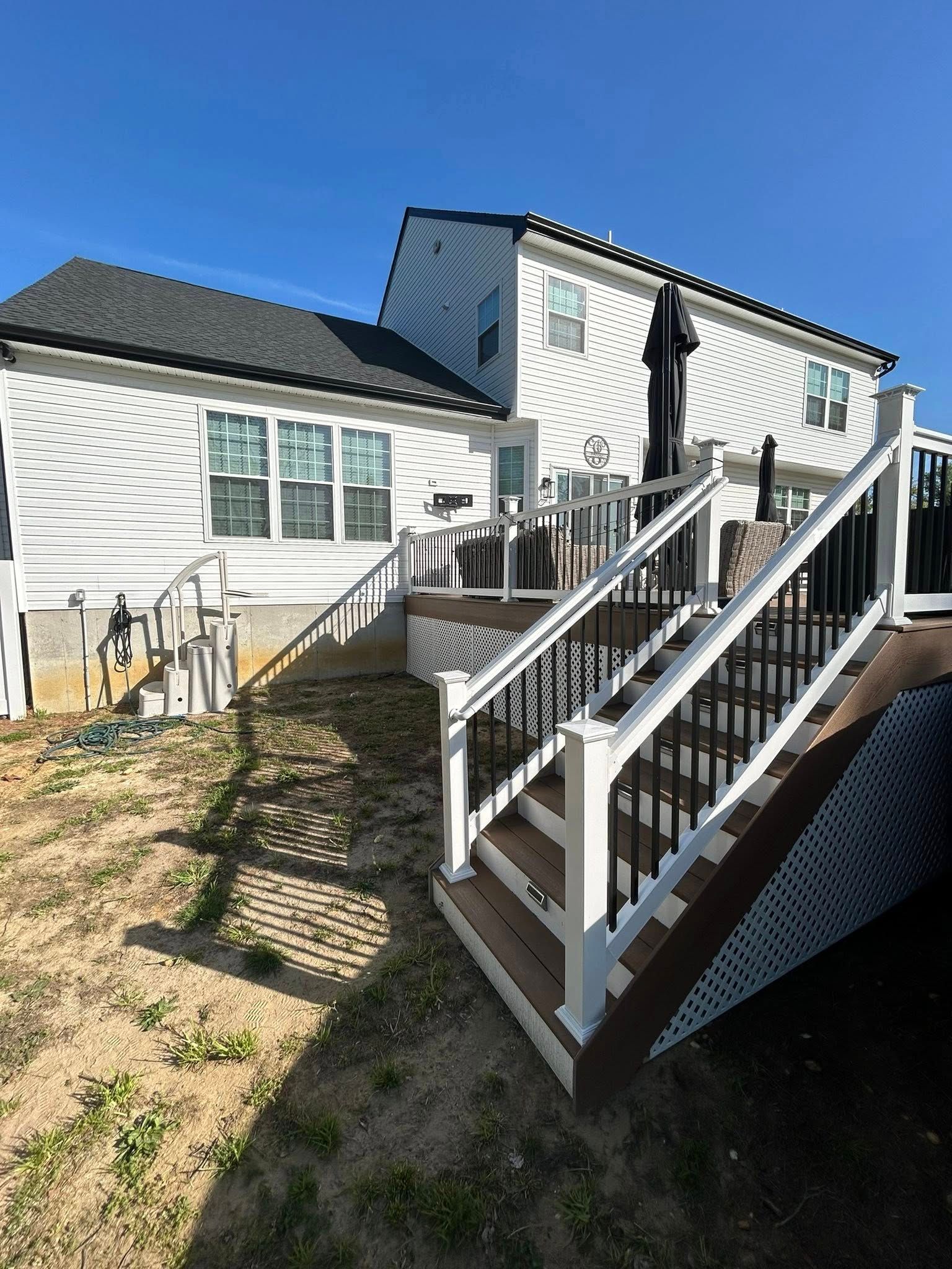 Two-story house with a wooden deck and stairs. 