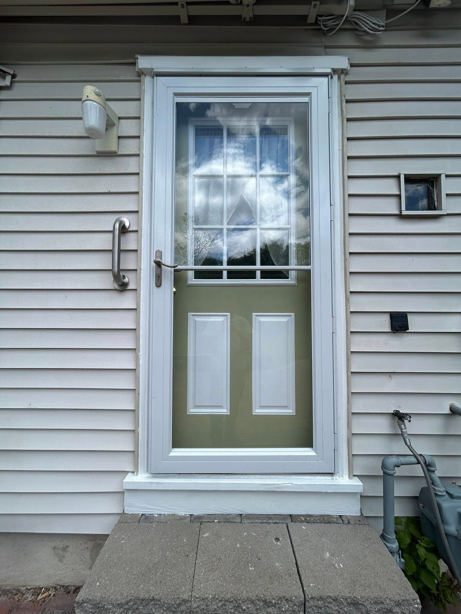 Exterior door with screen, white frame, olive-green lower panel.
