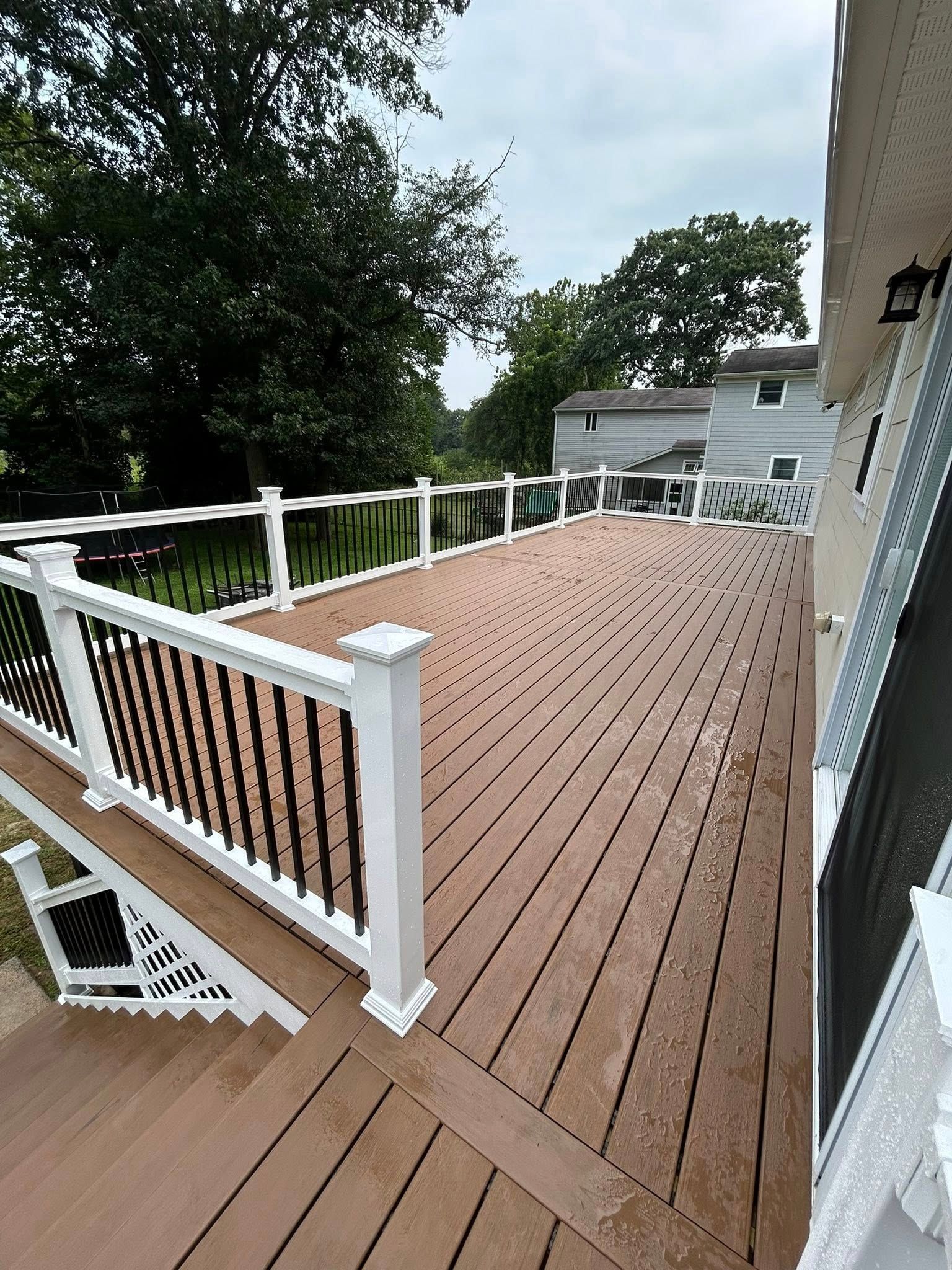 Wooden deck with white railings and black spindles.