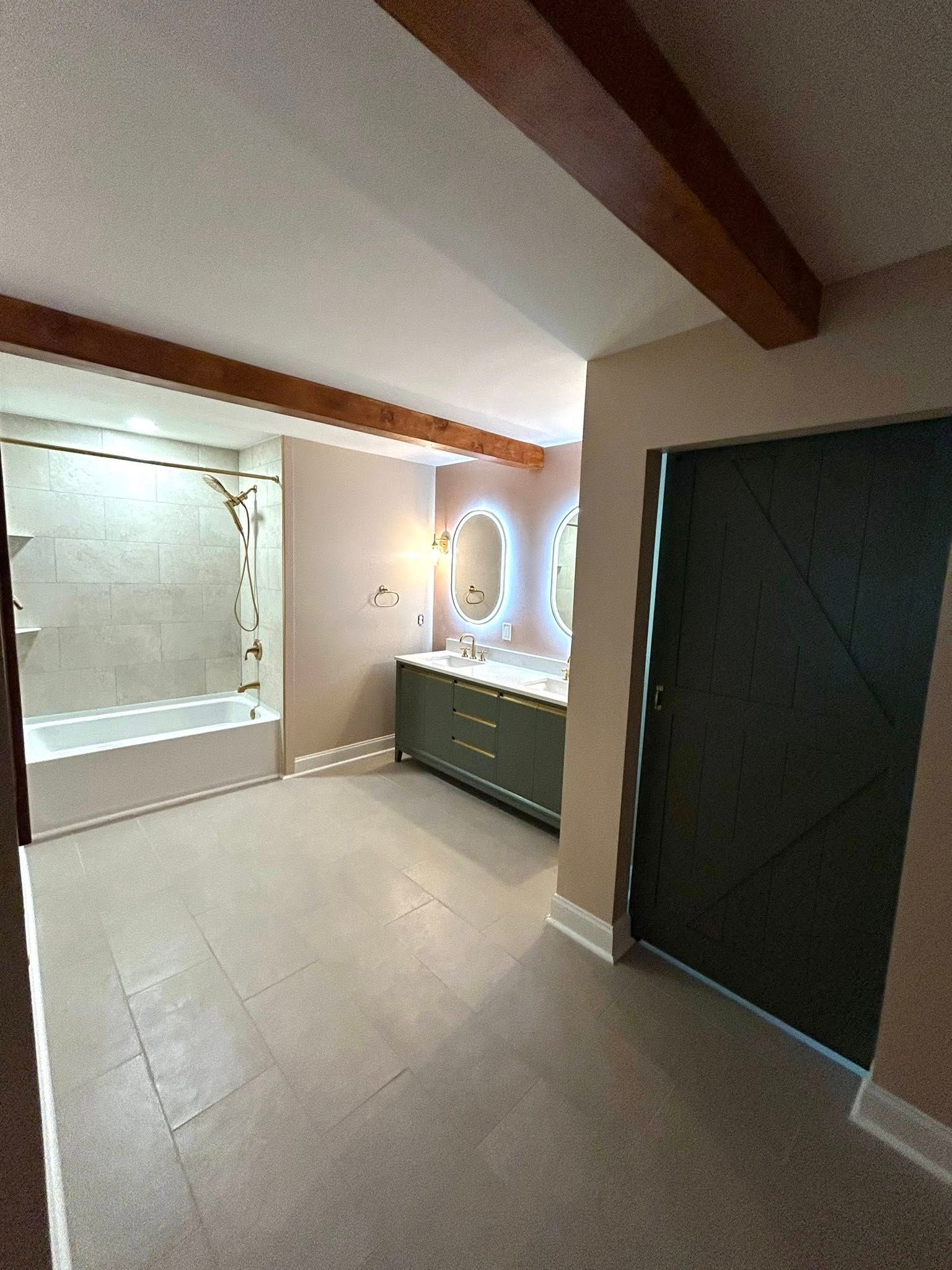 Bathroom with gray floor, tan walls, green vanity, and white-tiled shower.