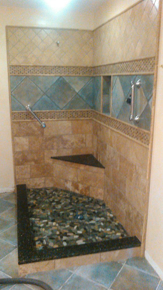 A bathroom with a walk in shower and a tiled floor.