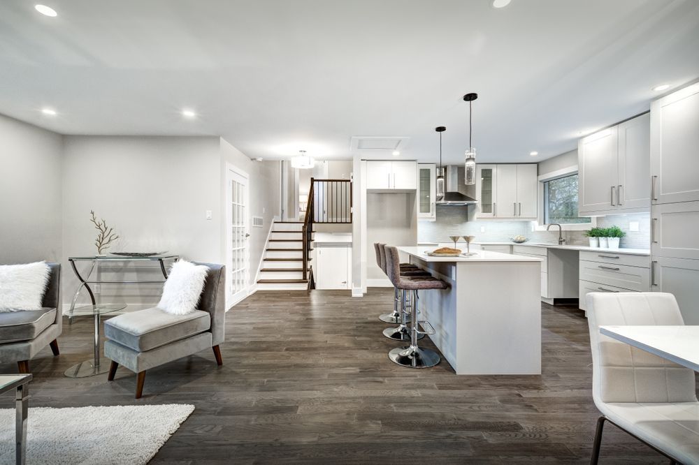 A living room filled with furniture and a kitchen with a large island.