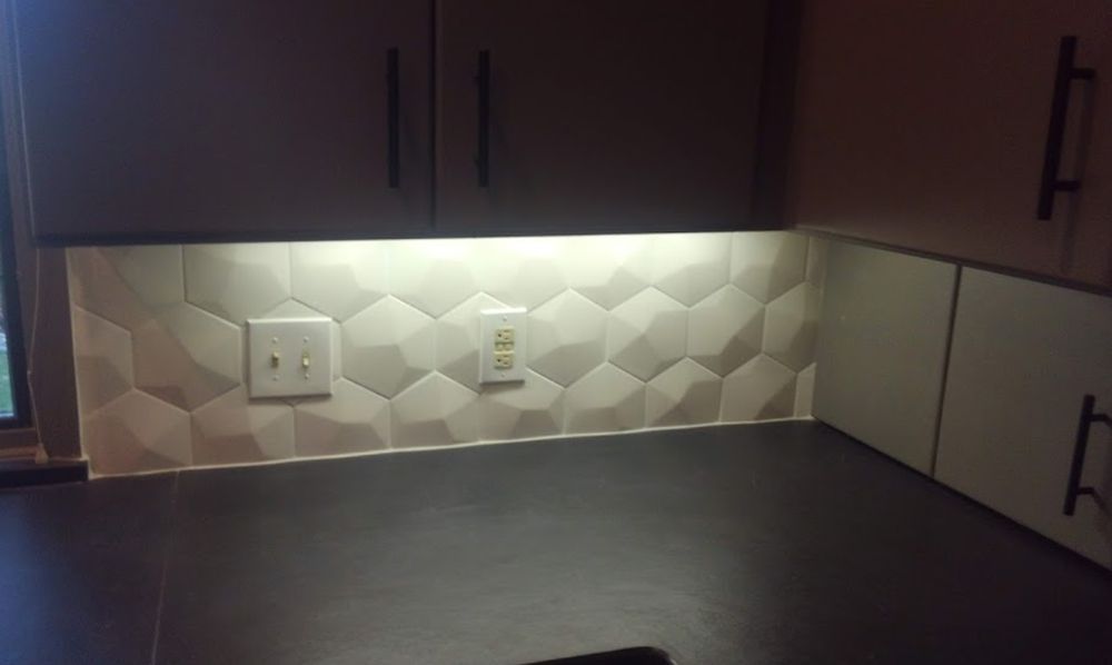 A kitchen with a geometric pattern on the wall