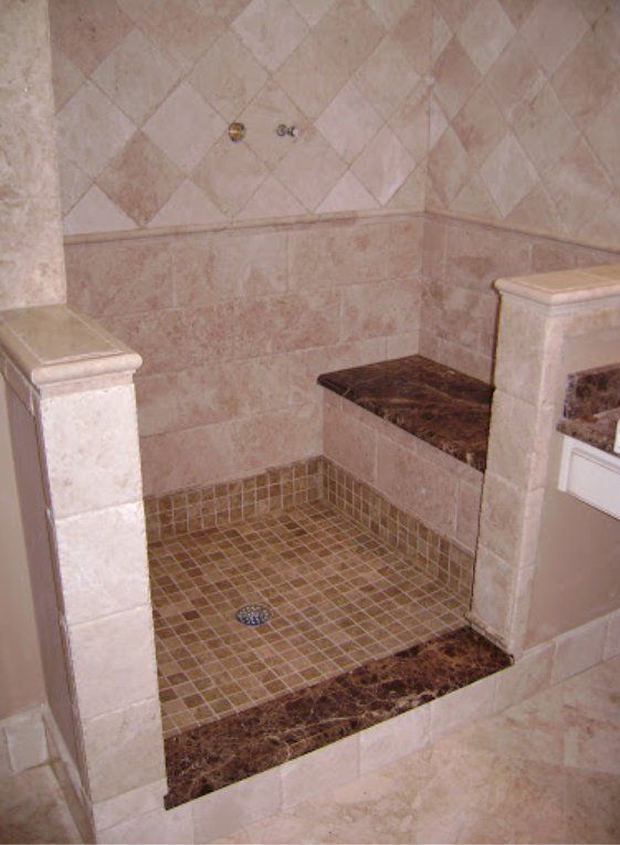 A bathroom with a walk in shower and a bench.
