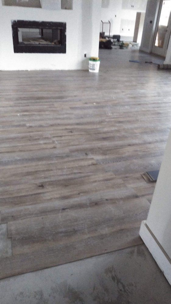 A living room with a wooden floor and a fireplace.
