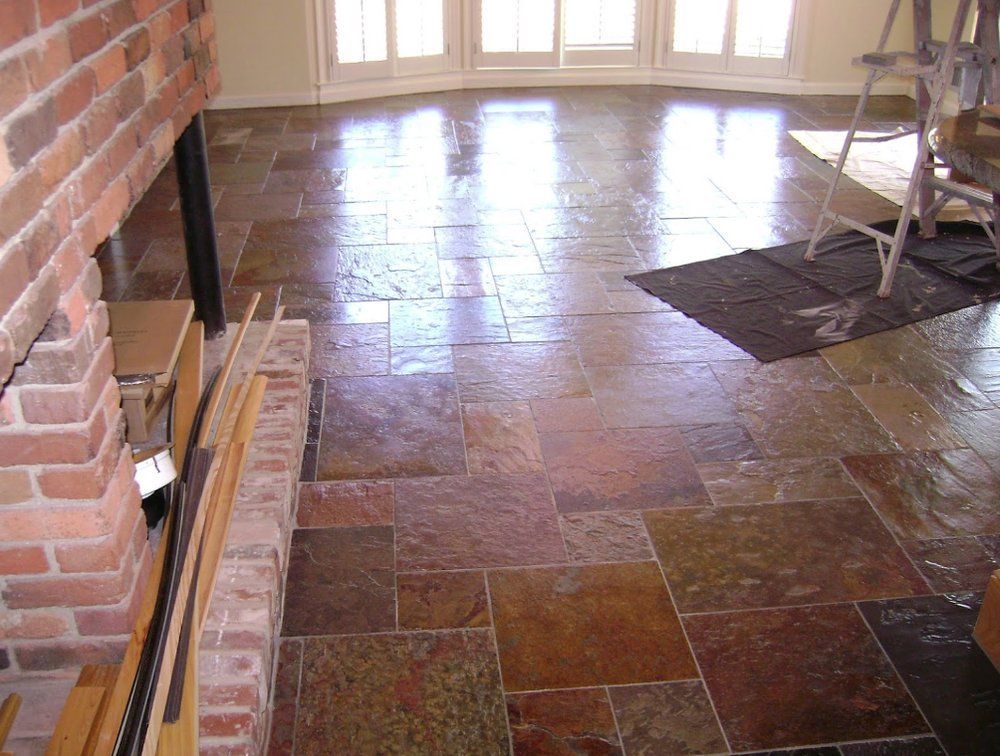 A tiled floor with a brick fireplace in the background.