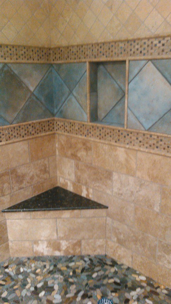 A bathroom with tiled walls and a corner shelf.