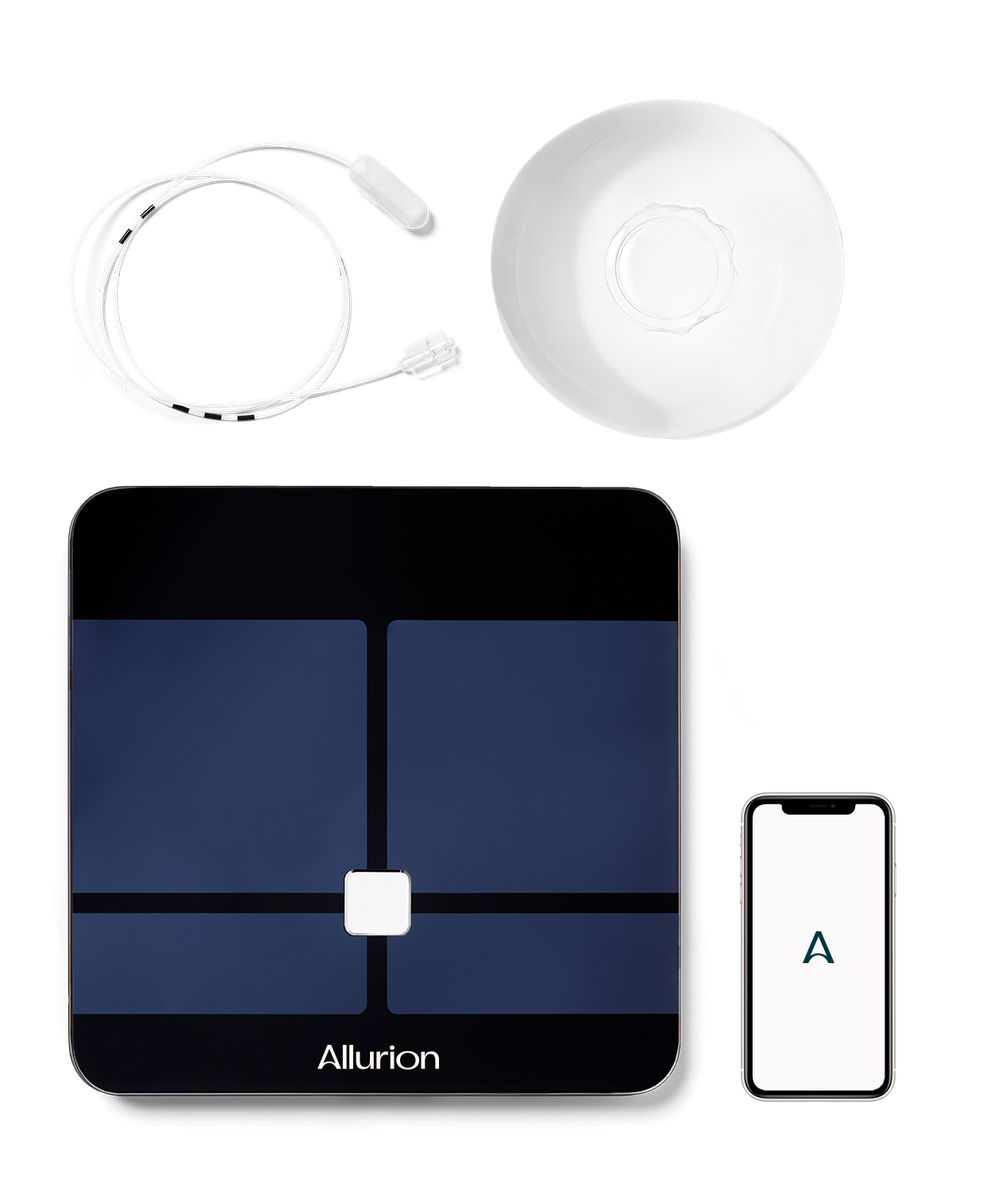 A smart scale , a smart watch , a phone , and a plate are sitting on a table.