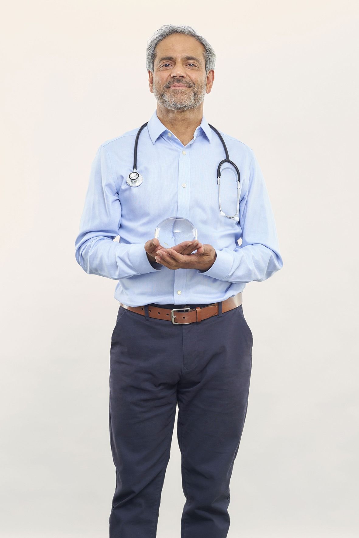 A doctor with a stethoscope around his neck is holding an Allurion Gastric Balloon that has been filled with 550ml of saline solution