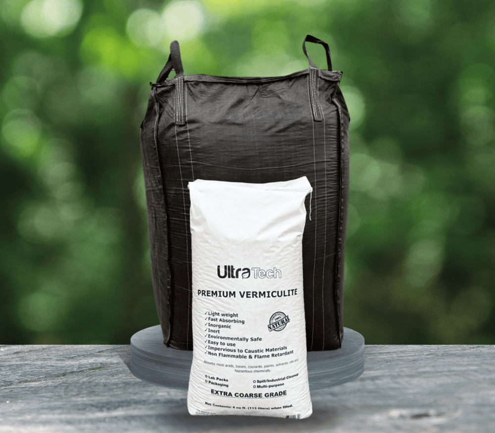 Black bulk bag and white bag of vermiculite, on a gray platform against a green backdrop.