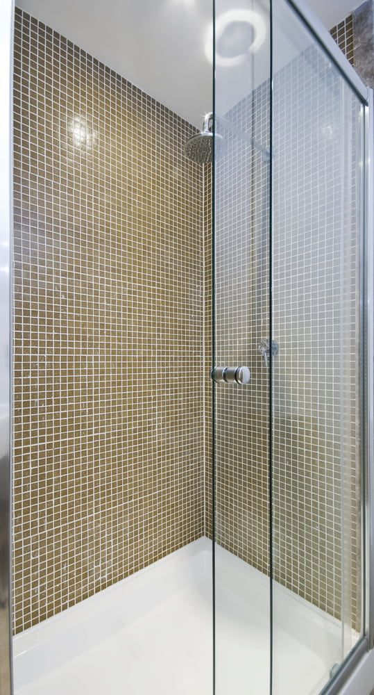 A Shower Stall With Sliding Glass Doors And A Shower Head — Hayes & Swinburn Glass In Westcourt, QLD