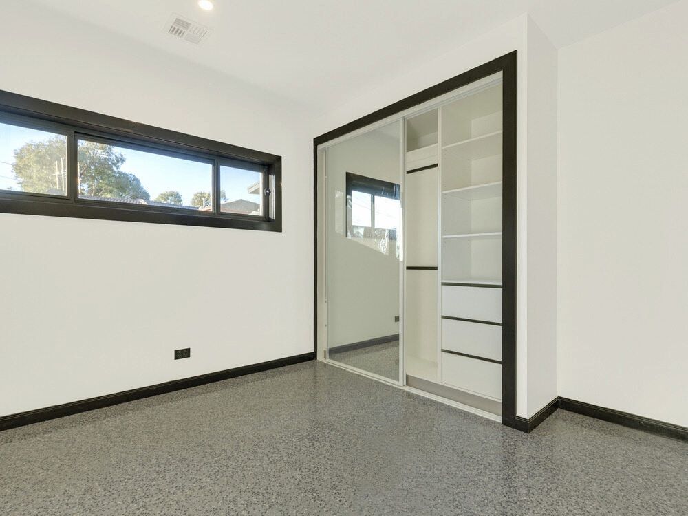 An Empty Room With A Sliding Glass Door And A Mirrored Wardrobe — Hayes & Swinburn Glass in Westcourt, QLD