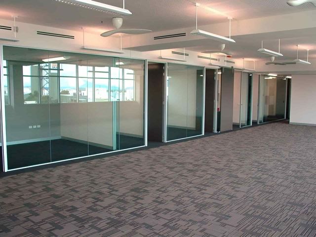 A Large Room With a Lot of Windows and a Carpeted Floor — Hayes & Swinburn Glass in Westcourt, QLD