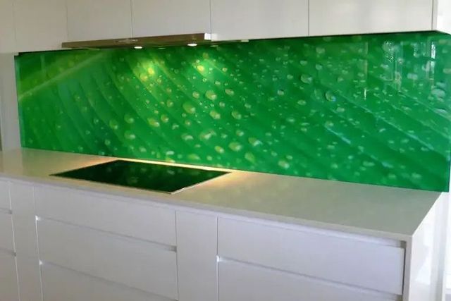 A Kitchen With White Cabinets and a Green Splash Back — Hayes & Swinburn Glass in Westcourt, QLD
