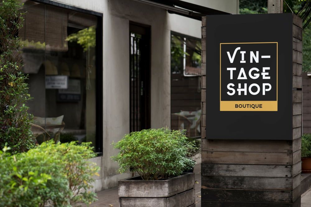 A Sign For A Vintage Shop Is Hanging Outside Of A Building — Hayes & Swinburn Glass in Westcourt, QLD