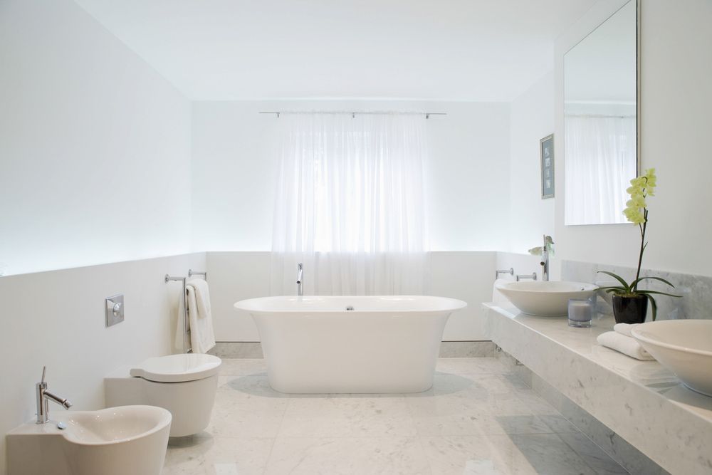 A Bathroom With A Bathtub, Toilet, Sink And Mirror — Hayes & Swinburn Glass in Westcourt, QLD