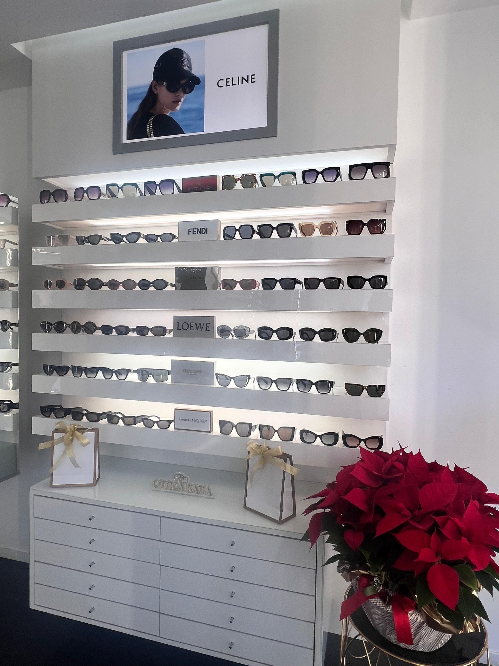 Espositore per occhiali da sole con più ripiani, una pubblicità di Chanel e una stella di Natale.