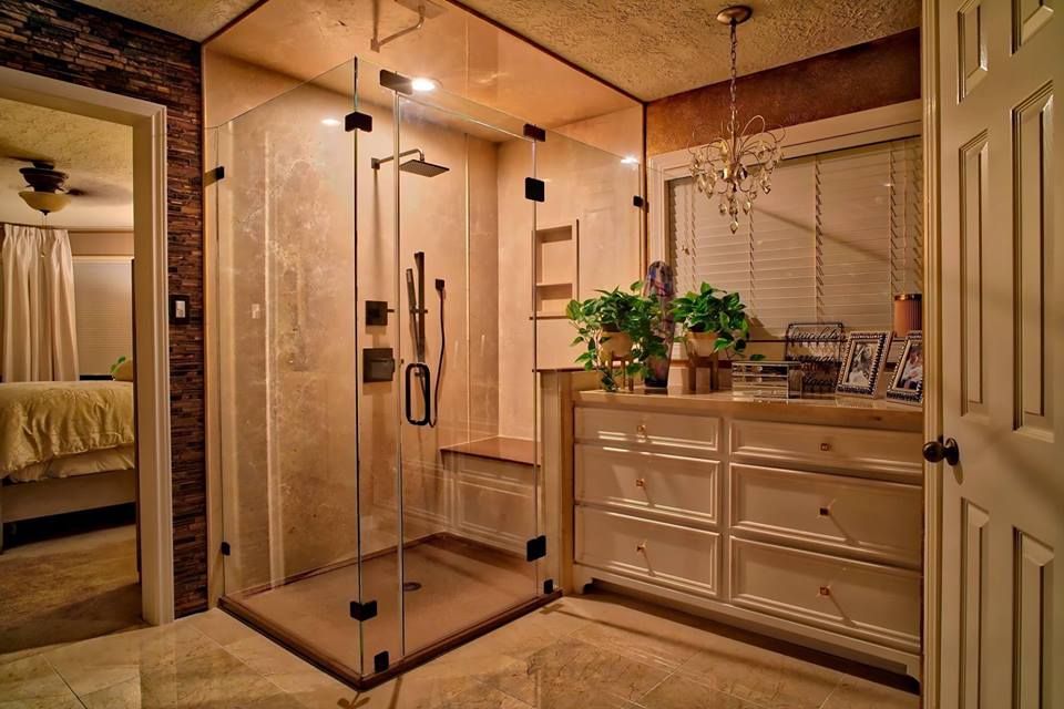 a bathroom with a walk in shower and a vanity .