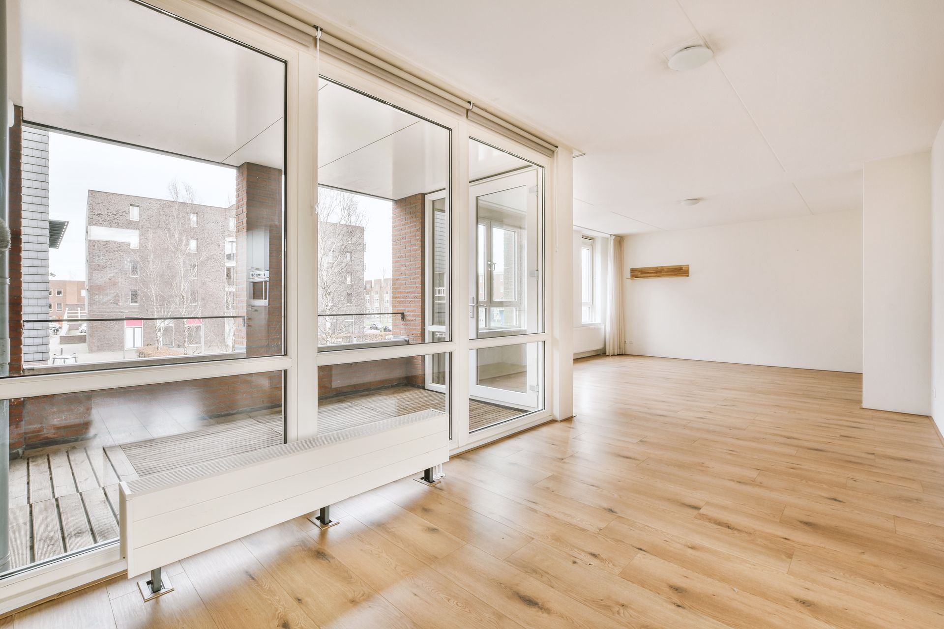 spacious bright empty room with large windows laminate flooring cozy house