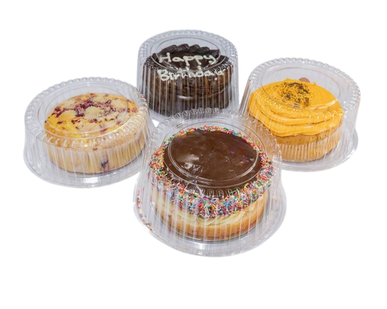 Four small cakes in clear plastic containers. Chocolate, yellow frosting, and fruit toppings  — Henri's Wodonga Bakery in Wodonga, VIC