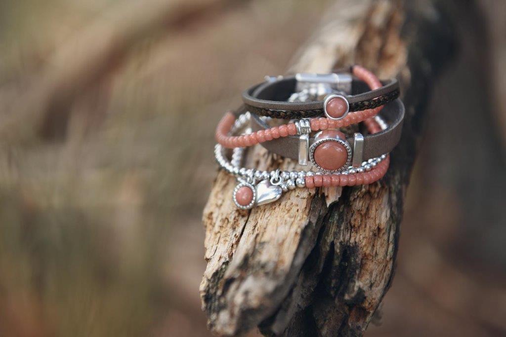 Eine Nahaufnahme eines Armbands, das auf einem Stück Holz liegt.