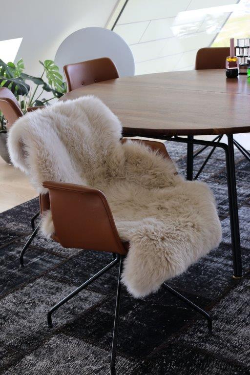 Vor einem Tisch steht ein Stuhl mit einer Felldecke darauf.