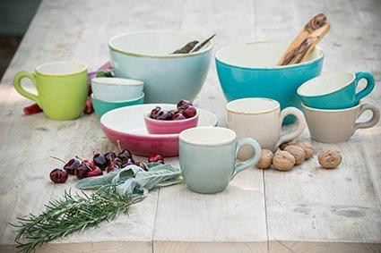 Ein Tisch mit einer Vielzahl von Schüsseln, Tassen und Tellern.