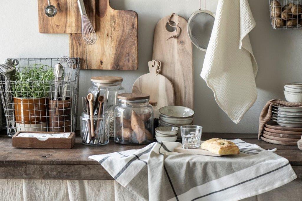 Eine Küchentheke mit einem Handtuch darauf und an der Wand hängenden Schneidebrettern.
