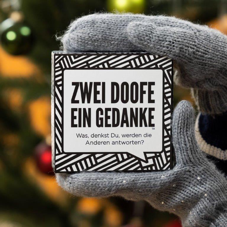 A person is holding a card that says zwei doofe ein gedanke