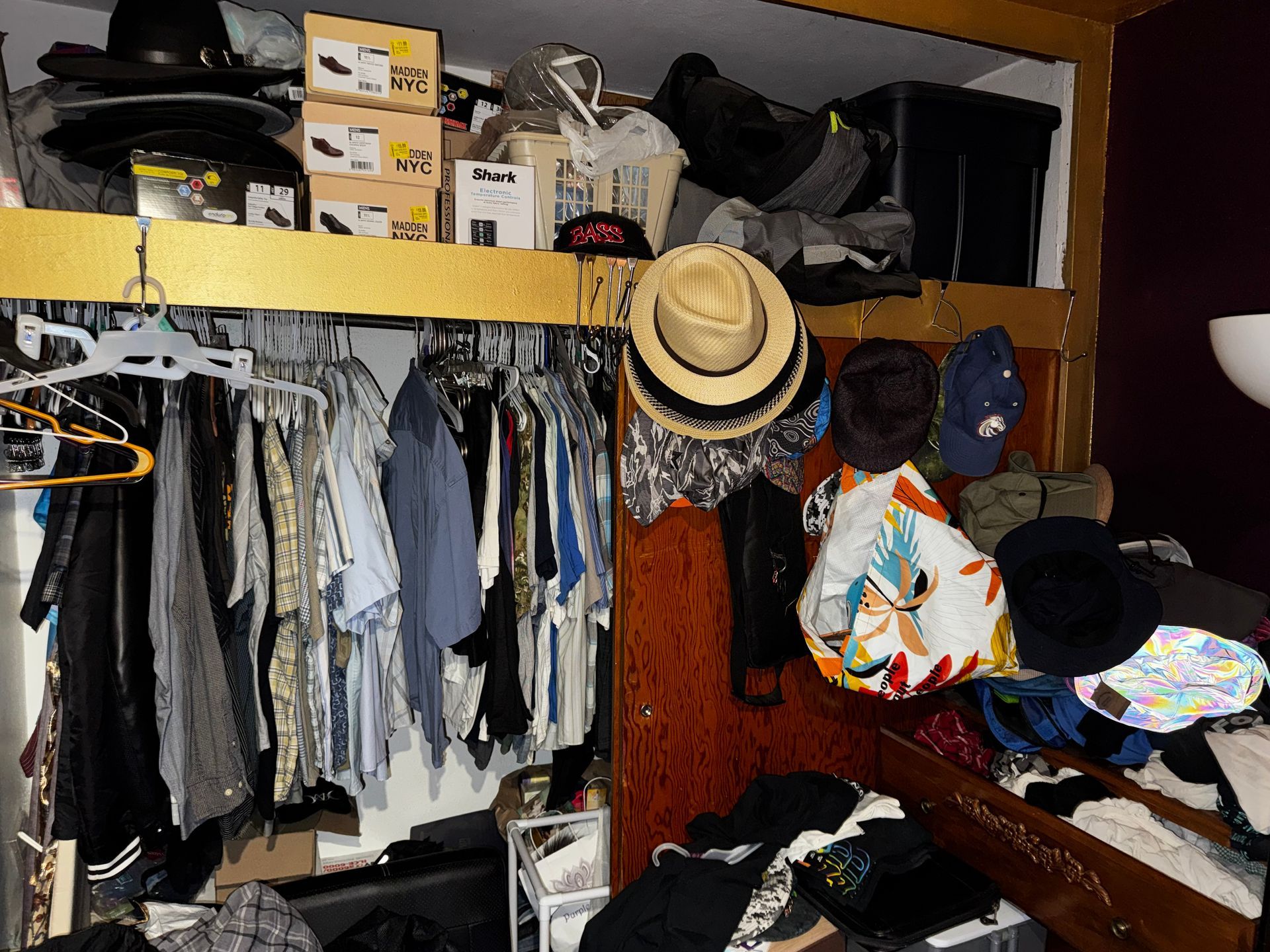Pile of debris, including wood and red chairs, in a side yard next to a light-colored building.