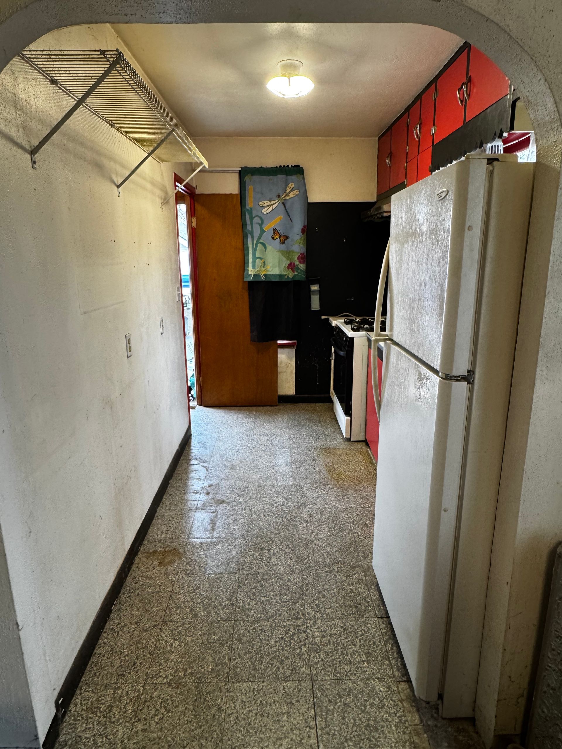 Stone slab and trash beside a wooden fence and a recycling bin.