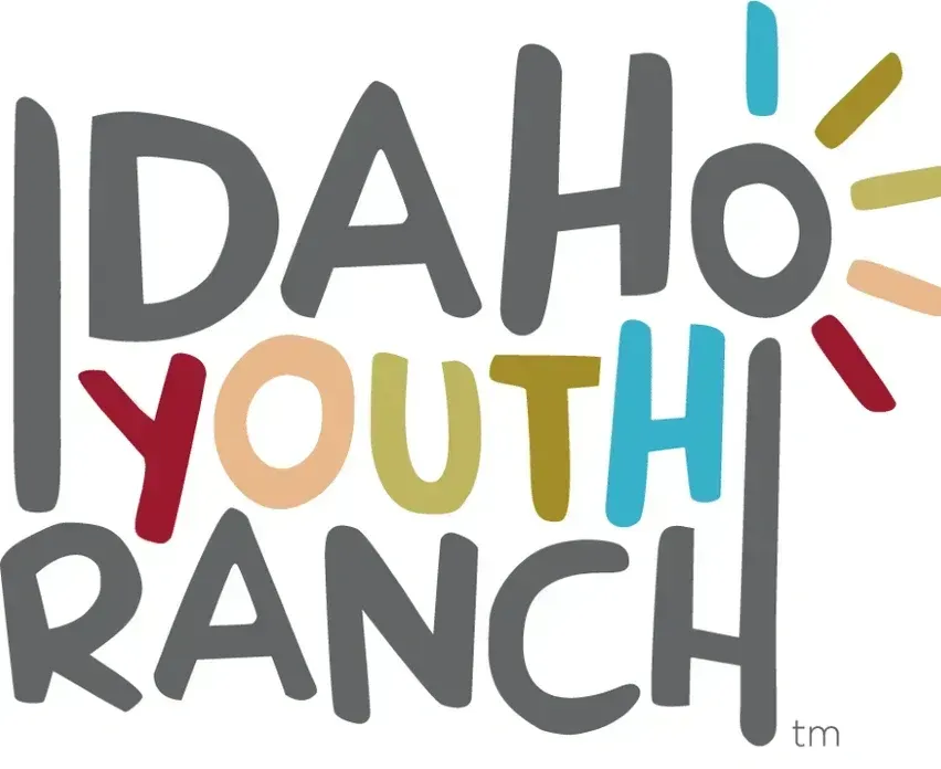 Idaho Youth Ranch logo with text in various colors and a sun graphic.