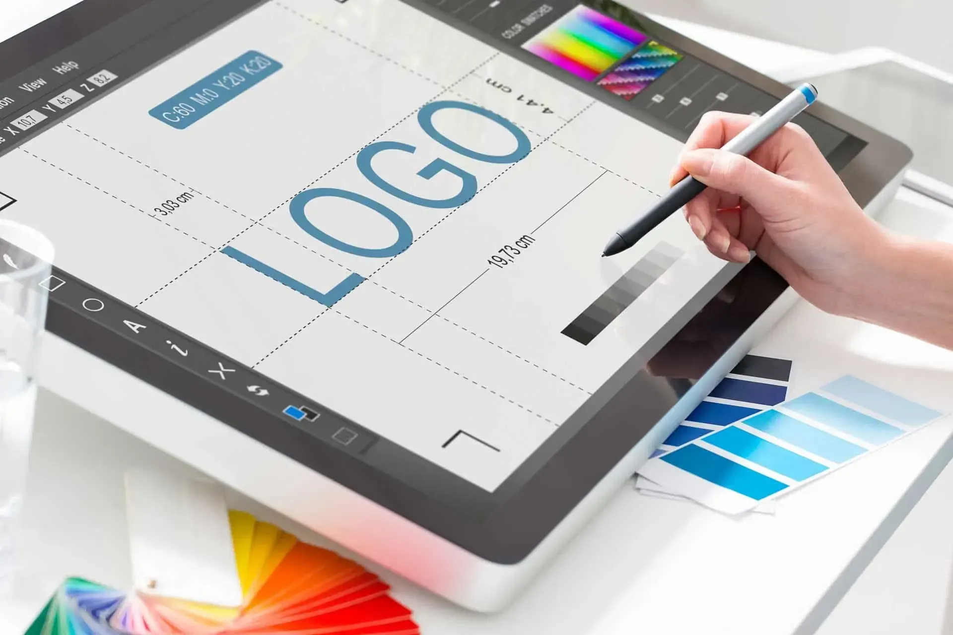 A person is drawing a logo on a tablet with a pen.