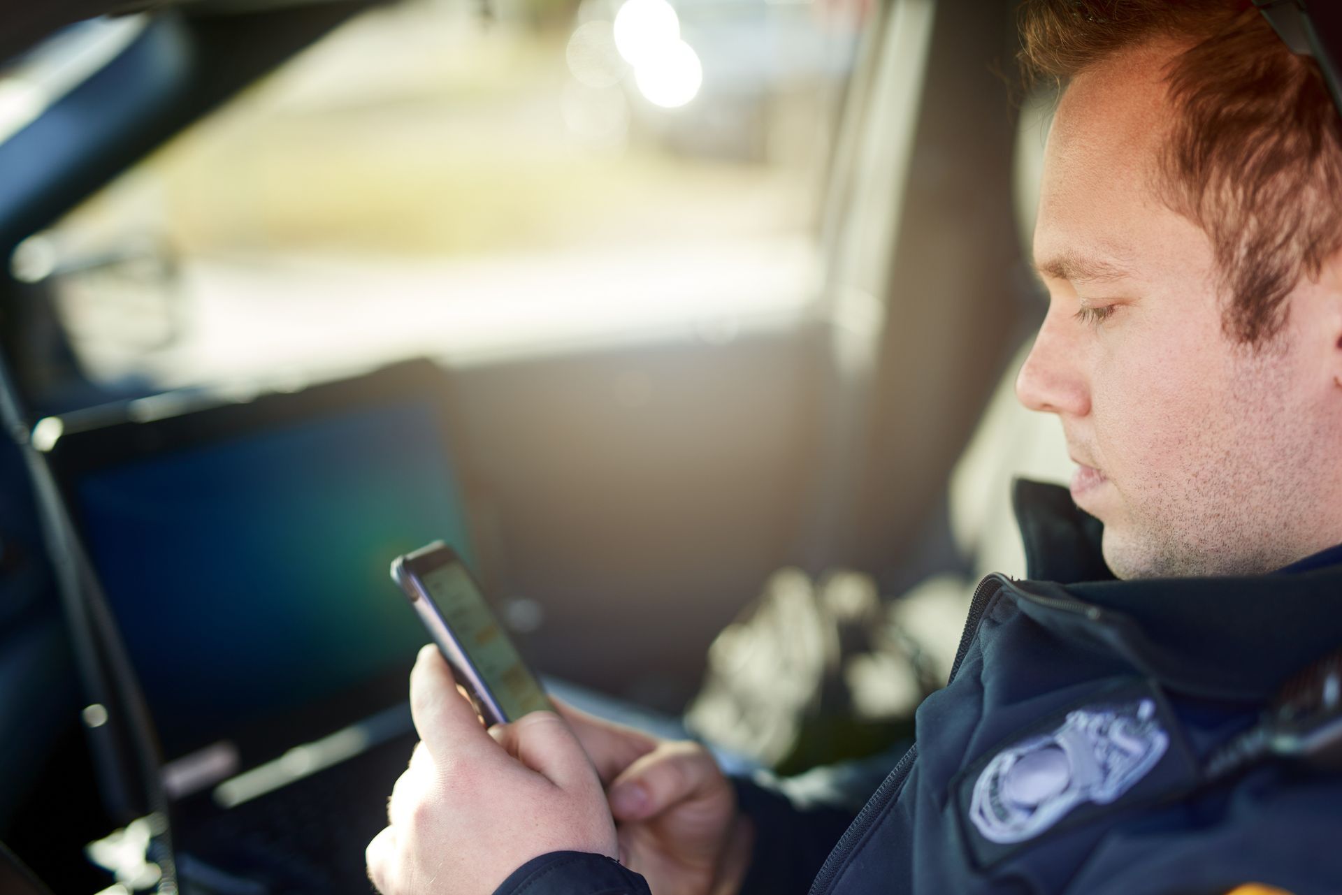 Male Police Officer Using His Cellphone - Eau Claire, WI - Cohen Law Offices, LLC