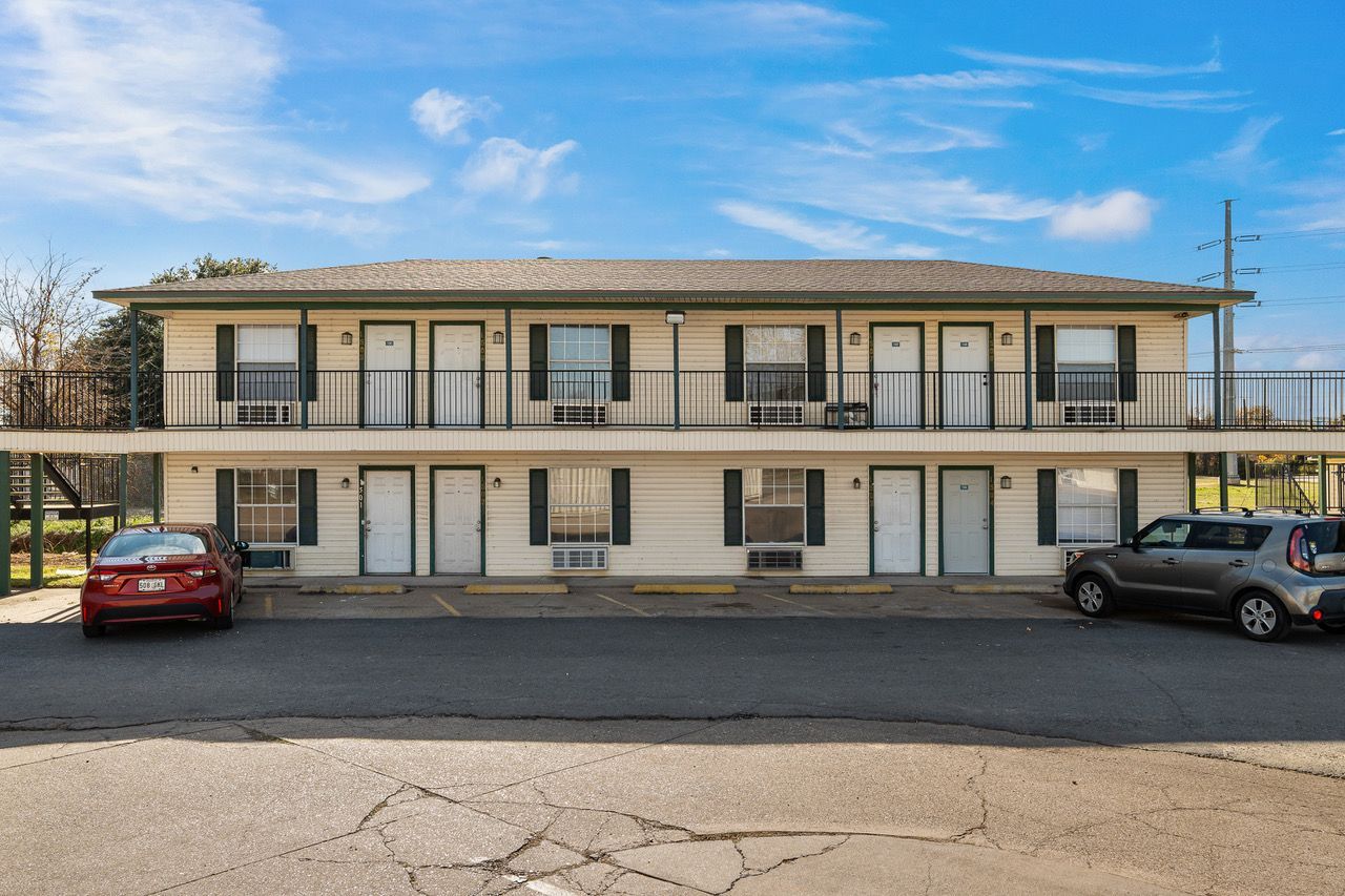a large apartment building with cars parked in front of it .