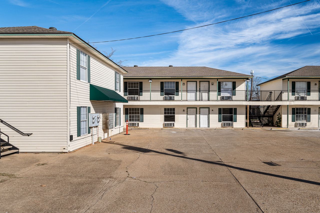a motel with stairs leading up to the second floor and a fire escape .