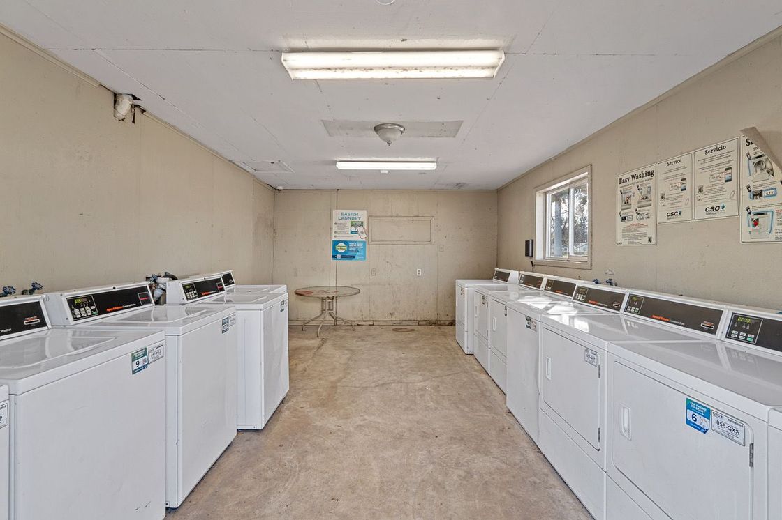 a laundromat filled with lots of washing machines and dryers .