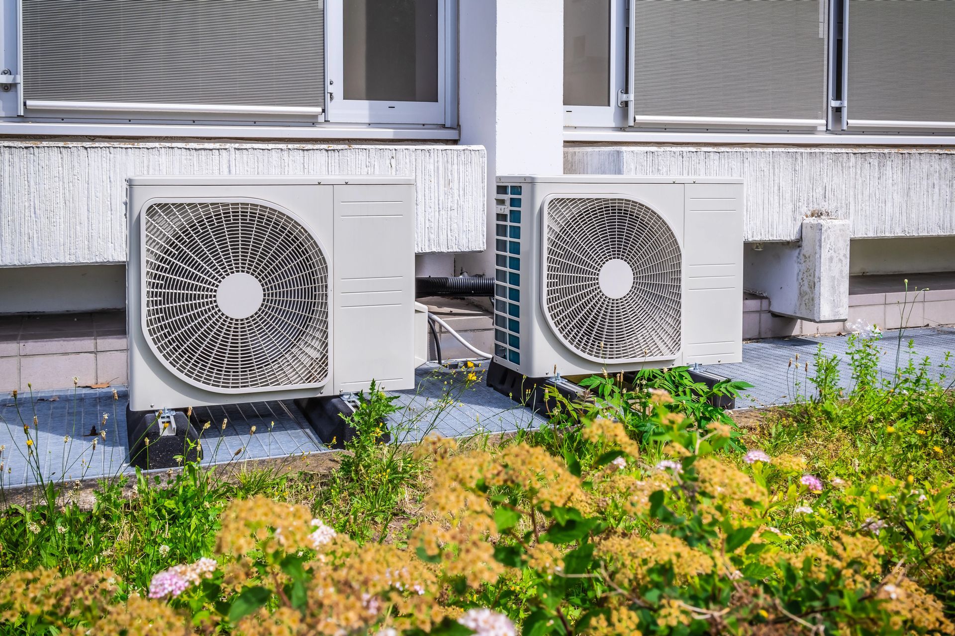 Cucina moderna con mobili in legno e neri, frigorifero in acciaio inox, tavolo da pranzo, lampade a sospensione.