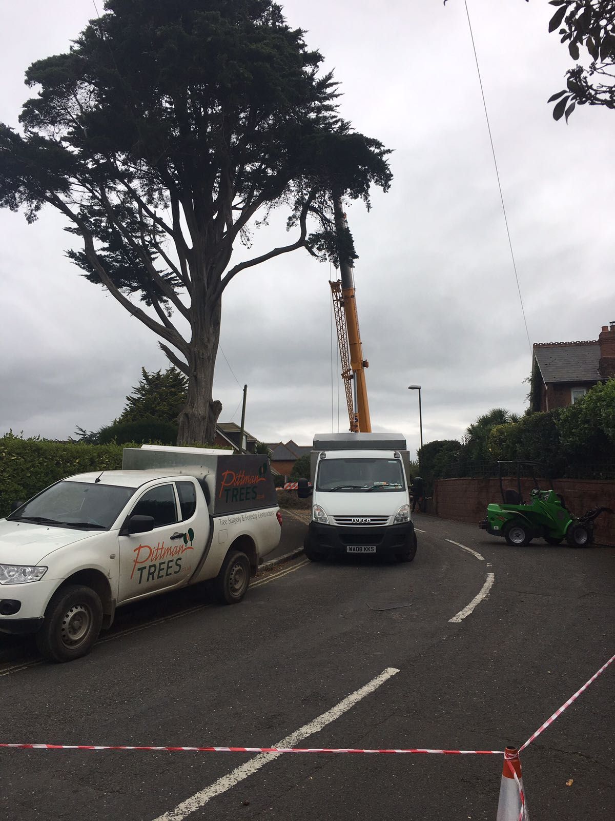 Two white trucks are parked on the side of the road