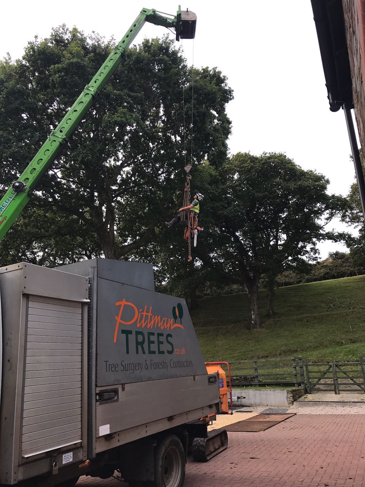 A truck with a crane attached to it is parked in front of a building.