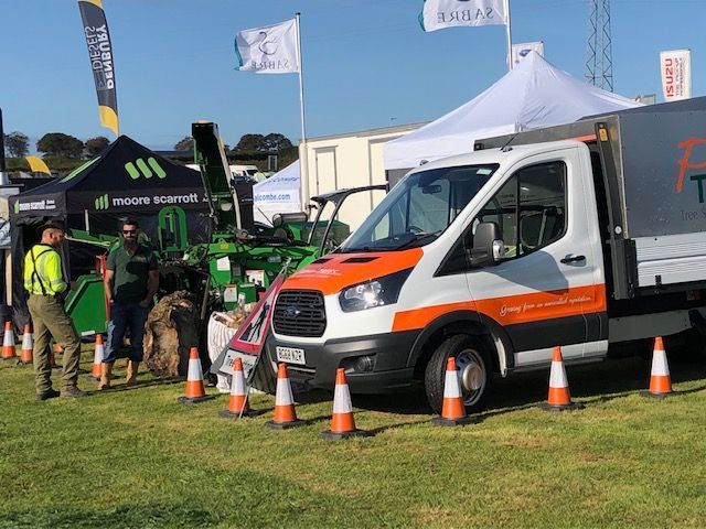 A white and orange van is parked in a grassy field.
