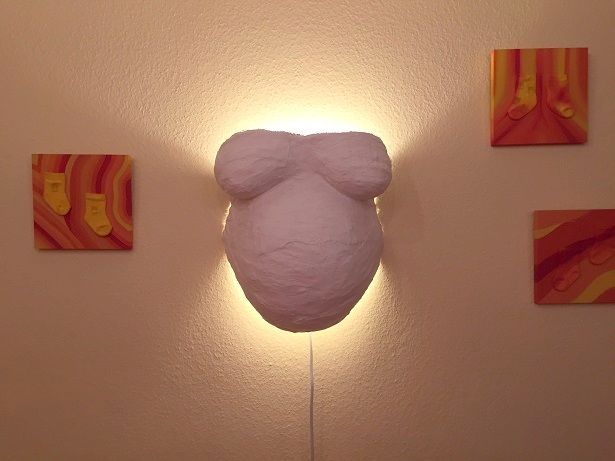 Gipsabguss eines schwangeren Bauches mit Brust.