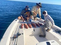 A group of men are fishing on a boat in the ocean.