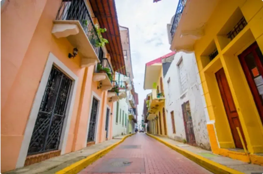 A narrow street lined with colorful buildings and a yellow curb.