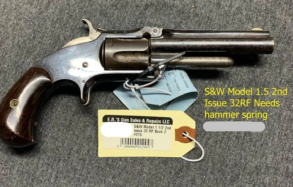 A revolver with a tag attached to it is sitting on a table.