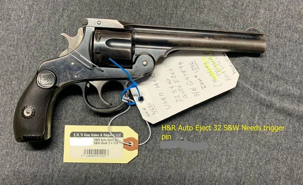 A revolver with a tag attached to it is sitting on a table.