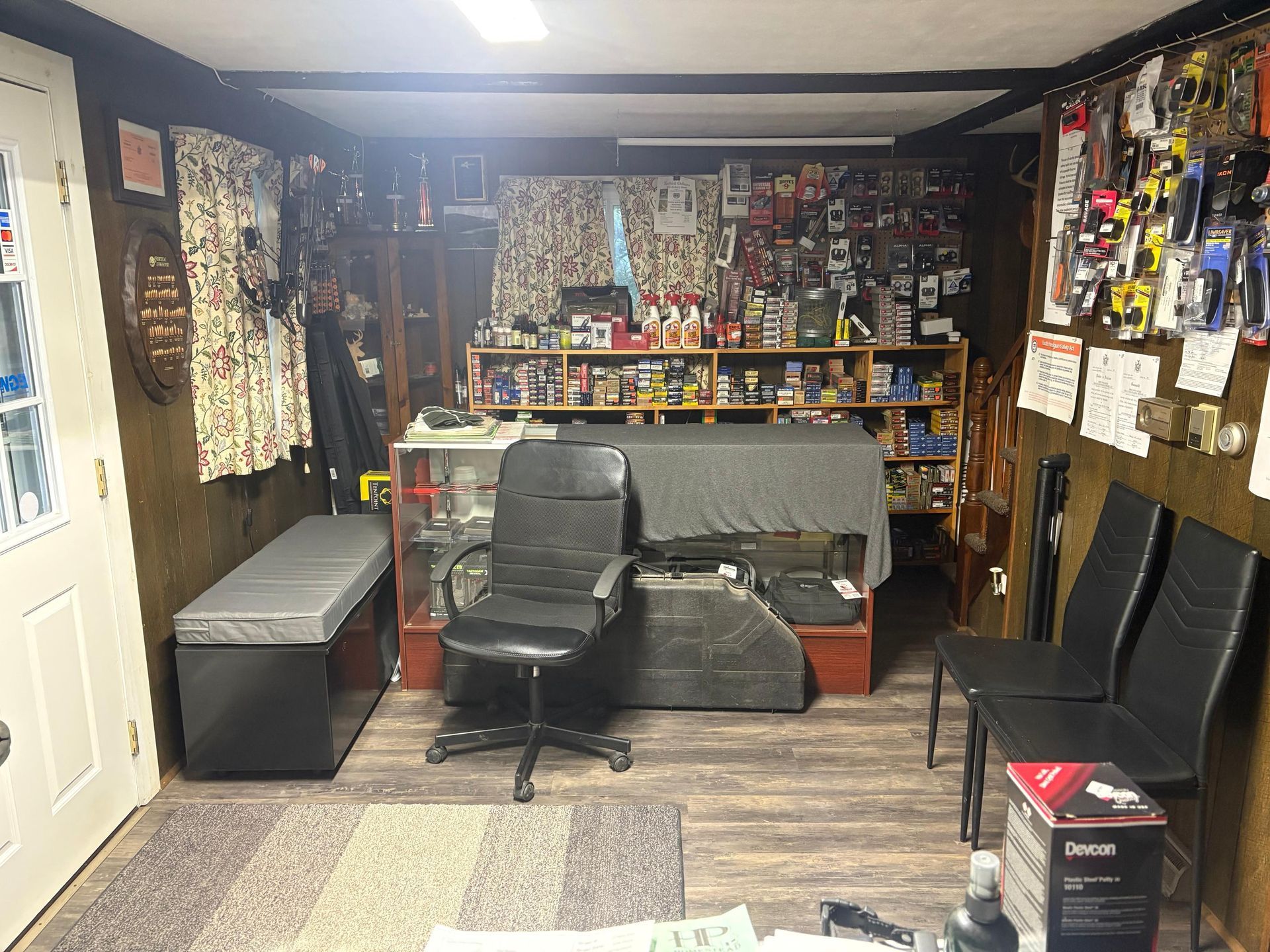 A room with a couch , chairs , shelves and a table.