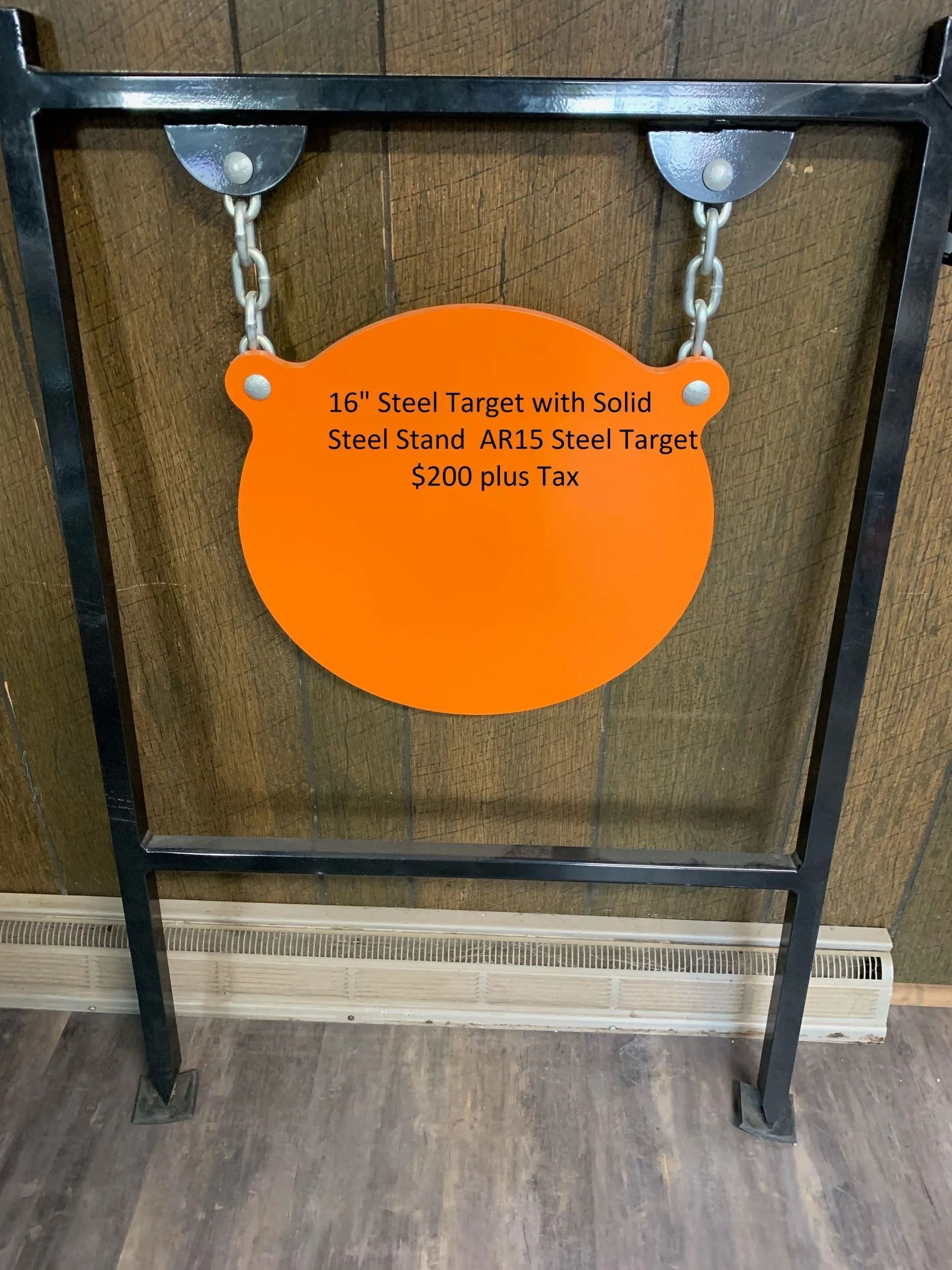 An orange target is hanging from chains on a metal frame.
